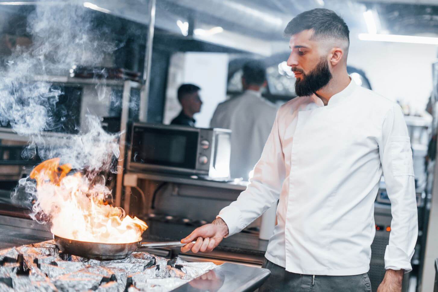 Chef cooking with fire in kitchen